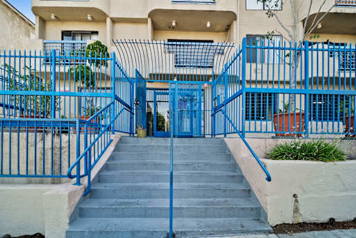 A blue gate leads to a building entrance.