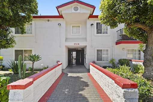 A white building with a red roof and a black awning with the number 5708 on it.