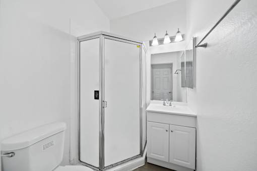 A white bathroom with a tub, sink, and medicine cabinet.