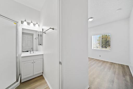 A white bathroom with a sink and a mirror.