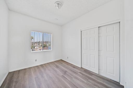 A room with a white door and a window with a view of a city.