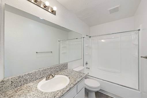 A bathroom with a sink, toilet, and shower.