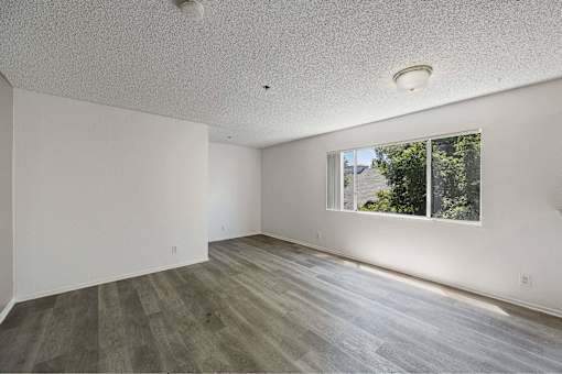 A room with a window and wooden flooring.