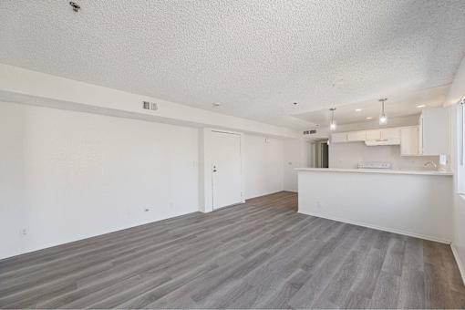 A spacious room with a grey floor and white walls.