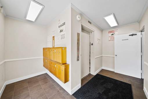 A hallway with a black rug and a yellow filing cabinet.