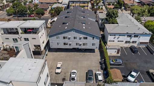 A parking lot with cars and a building in the background.