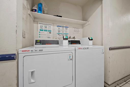 A Washing Machine and Dryer are in a small room.
