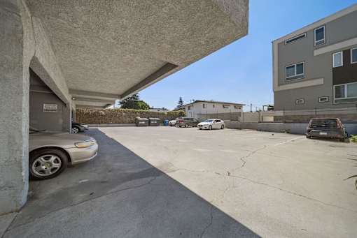 A parking lot with cars and a building in the background.