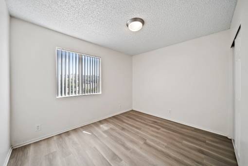 A room with a window and wooden flooring.