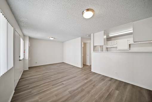 A room with a light brown floor and white walls.