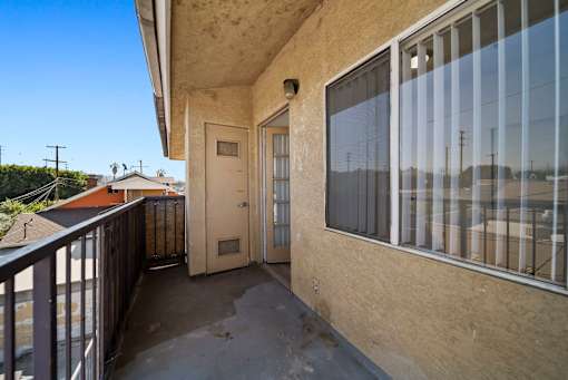 A balcony with a door and a window.