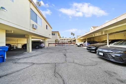 A parking lot with cars and a building in the background.
