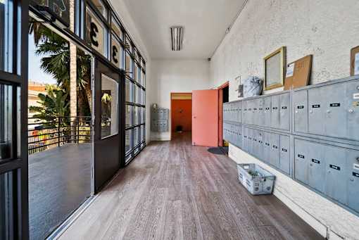 A long hallway with a row of lockers on the right and a door at the end.
