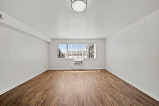 Empty room with wooden floor and white walls.