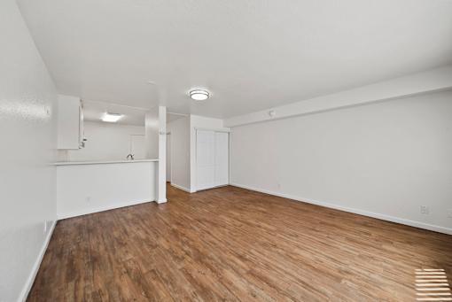 A room with wooden flooring and white walls.