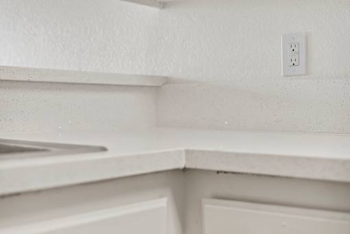 A white electrical outlet on a white wall.