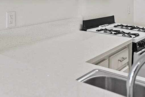 A black and white photo of a kitchen with a stove and sink.