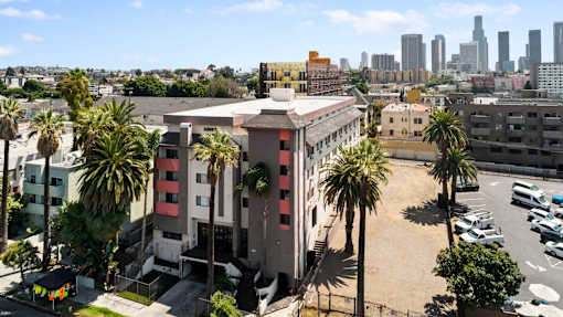 A building with a red and white striped facade is surrounded by palm trees.