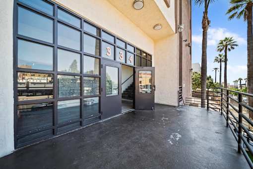 The image shows a building entrance with a glass door and a sign above it.