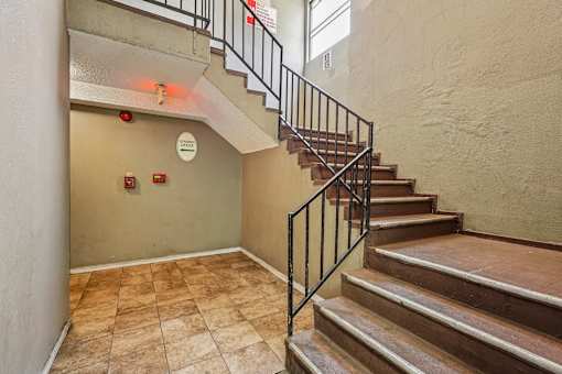 A staircase with a metal railing and wooden steps.