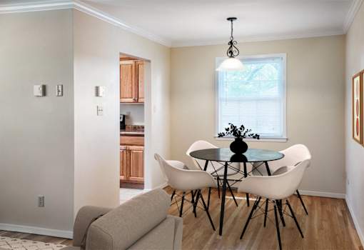 A dining room with a glass table and white chairs at Rivercrest Apartments, Piscataway
