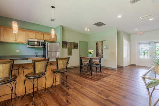 A kitchen with wooden floors and a dining table with chairs at Imperial Gardens Apartments, Clearwater, FL, 33764