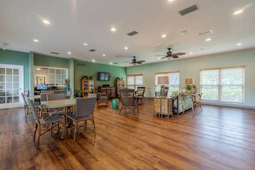 A spacious room with wooden floors and a dining table set up with chairs at Imperial Gardens Apartments, Clearwater, Florida