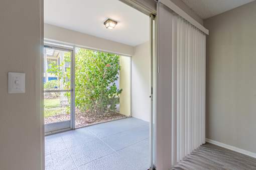 A room with a sliding door leading to a garden at Imperial Gardens Apartments, Florida, 33764