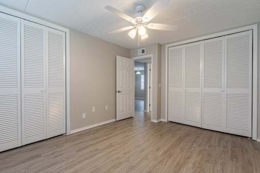 A room with a ceiling fan and sliding doors at Imperial Gardens Apartments, Clearwater, FL