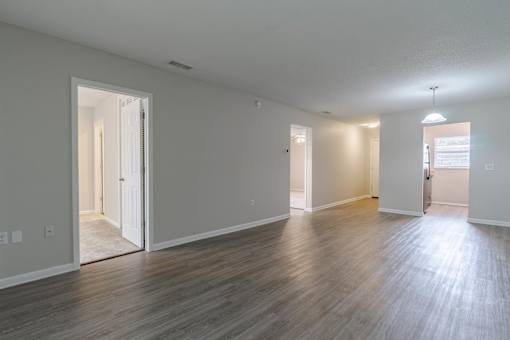 A spacious room with wooden flooring and white walls at Imperial Gardens Apartments, Florida