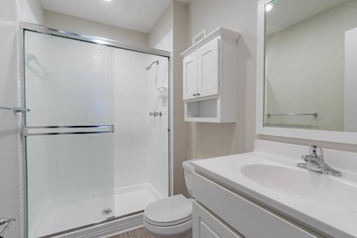 A white bathroom with a toilet, sink, and shower at Imperial Gardens Apartments, Florida, 33764