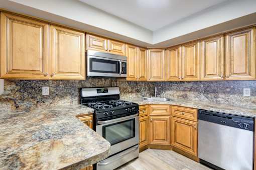 A kitchen with wooden cabinets and granite countertops at Seaview Apartments in Staten Island, NY, 10305