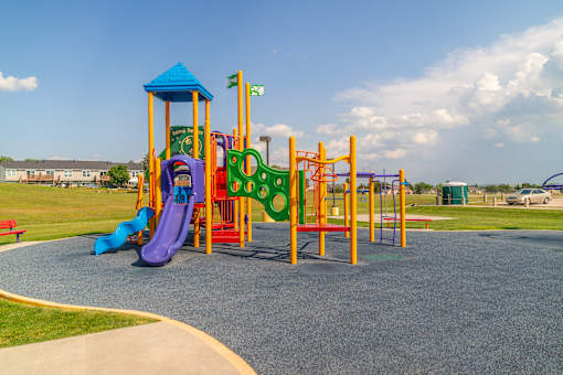 A playground with a purple slide and a yellow and green structure.