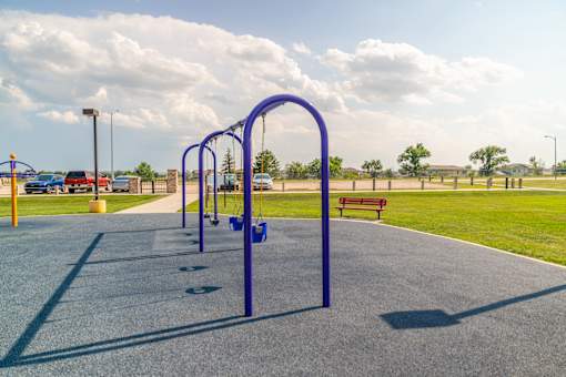 A blue swing set and parking lot.