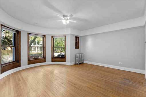 A room with wooden floors and a ceiling fan.