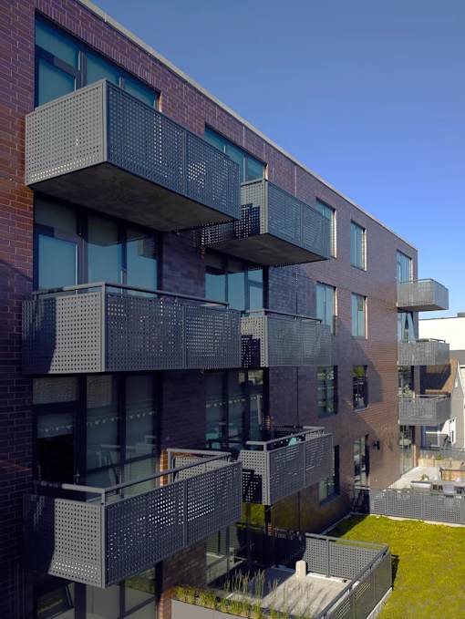 A modern building with a balcony and glass windows.