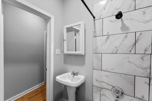 A white sink in a bathroom with marble tiles.