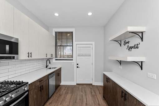 A modern kitchen with a white countertop and wooden cabinets.