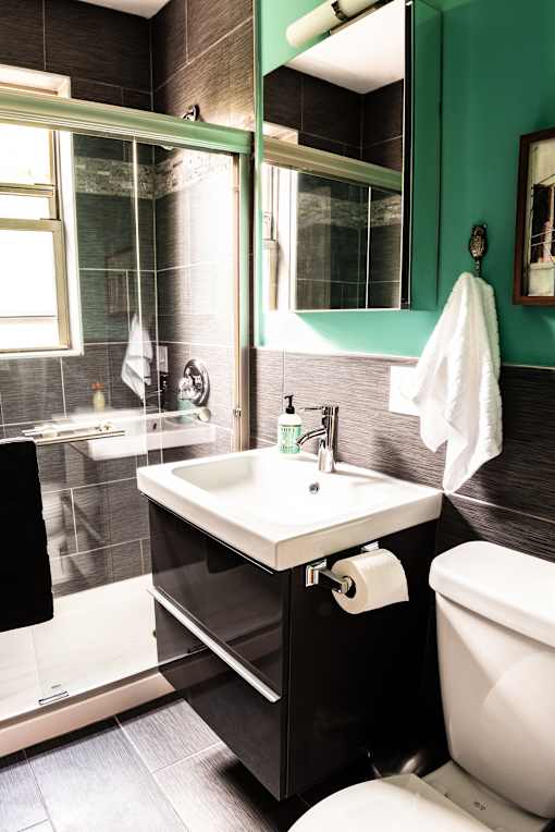 A white sink in a black and green bathroom.