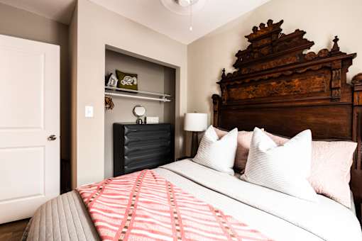 A bedroom with a large bed and a wooden headboard.