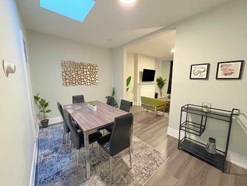A dining room with a table and chairs.