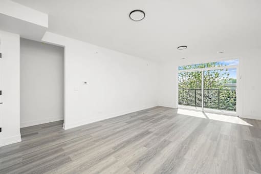 A spacious room with a large window and a sliding glass door.