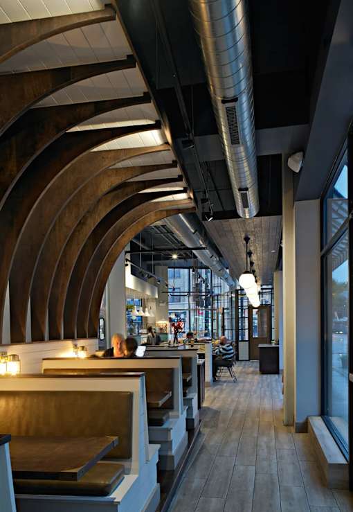 A modern restaurant with wooden tables and chairs.