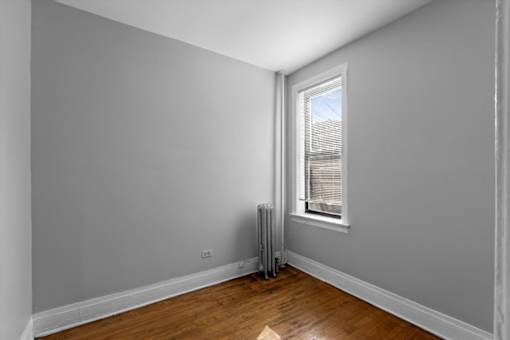 A room with a window and a radiator on the wall.