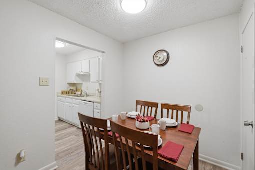 A dining room with a table set for four.