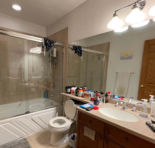 A bathroom with a toilet, sink, and shower.
