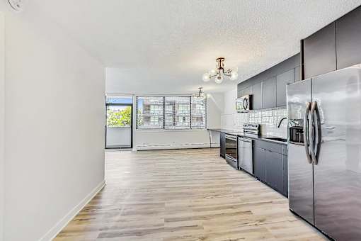A kitchen with a refrigerator on the right side.