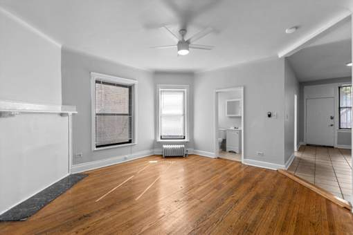 A room with wooden floors and a ceiling fan.