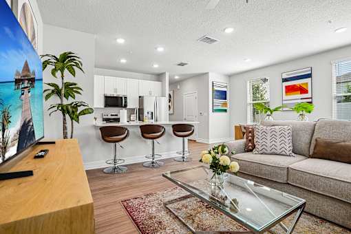 A living room with a glass coffee table and a television.