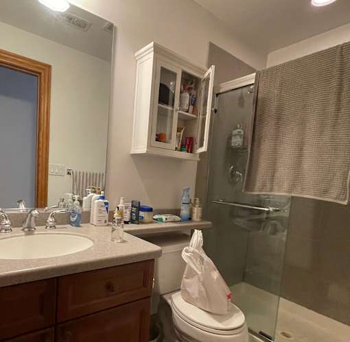 A bathroom with a toilet, sink, and shower.